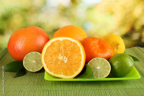 Photo: Fruits with leafs on table on bright background Fruits with leafs on table on bright background