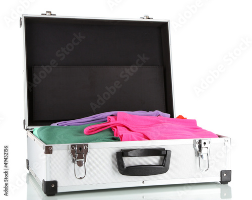 Photo: Open silver suitcase with clothing isolated on white Open silver suitcase with clothing isolated on white