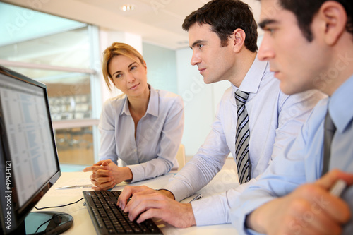 Photo: Business team working in front of desktop Business team working in front of desktop