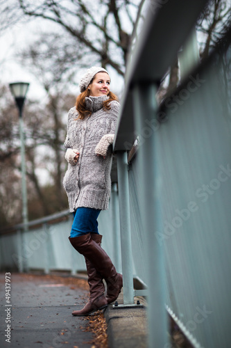 Photo: young woman dressed in a warm woolen cardigan young woman dressed in a warm woolen cardigan