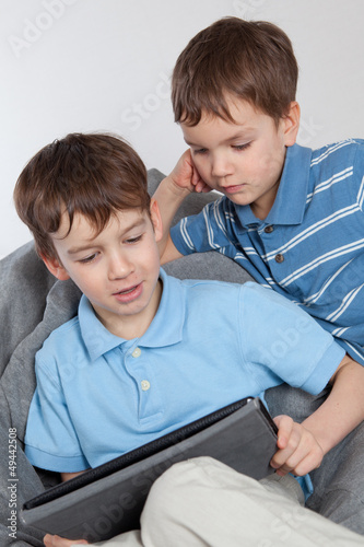 Photo: Two brothers playing on tablet Two brothers playing on tablet
