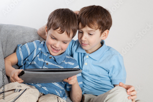 Photo: Two brothers playing on tablet Two brothers playing on tablet