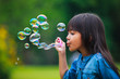 Foto: Asian little girl is blowing a soap bubbles Asian little girl is blowing a soap bubbles