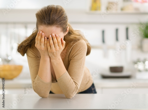 Photo: Stressed young woman in kitchen Stressed young woman in kitchen