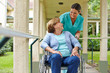 Seniorin im Rollstuhl spricht mit Krankenschwester