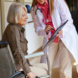 Krankenschwester bittet Seniorin um Unterschrift