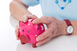 Rentnerin hält ihr Sparschwein fest in der Hand