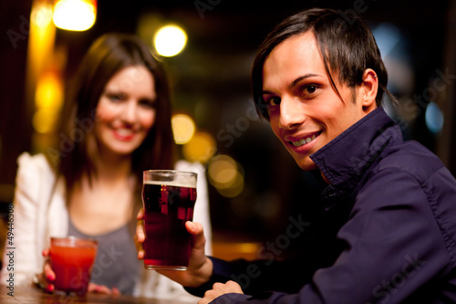 Photo: Couple of friends having a drink in a bar Couple of friends having a drink in a bar