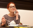 Beautiful young woman with a cup of cappuccino at a cafe 