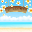 Wooden signboard Welcome & tropical flowers on beach