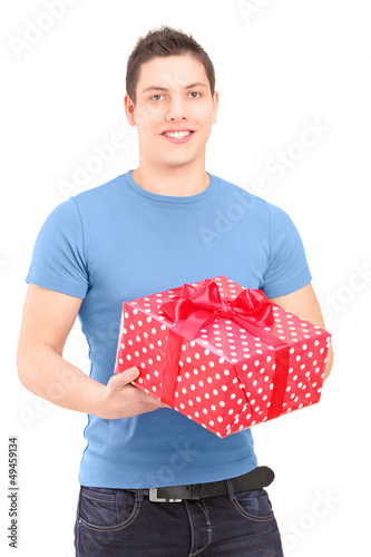 Photo: Smiling handsome guy holding a present Smiling handsome guy holding a present