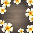 Tropical flowers and water drops on a wooden background