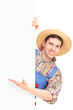 Young smiling farmer gesturing on a blank panel