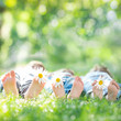 Family with flowers lying on green grass. Healthy lifestyle conc