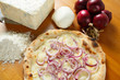 Italian Pizza, ingredients in the background on a wood table
