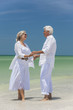 Happy Senior Couple Holding Hands on Tropical Beach