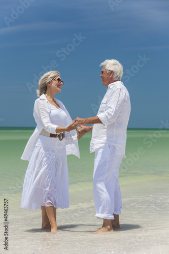 Photo: Happy Senior Couple Holding Hands on Tropical Beach Happy Senior Couple Holding Hands on Tropical Beach