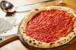 Italian Pizza, ingredients in the background on a wood table