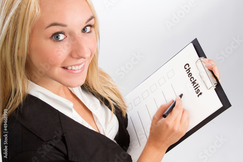Photo: Young woman with checklist over shoulder shot Young woman with checklist over shoulder shot