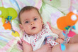 Little cute baby girl lying in crib with toy
