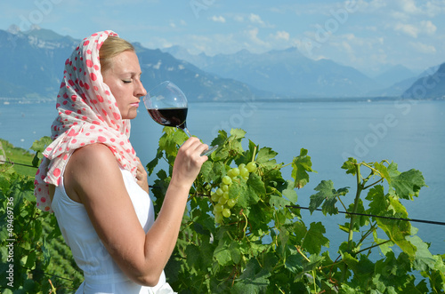 Photo: Woman tasting red wine in Lavaux, Switzerland Woman tasting red wine in Lavaux, Switzerland