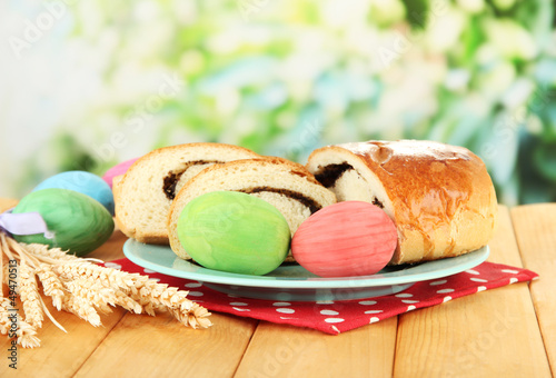 Photo: Loaf with poppy seeds on color plate, on bright background Loaf with poppy seeds on color plate, on bright background