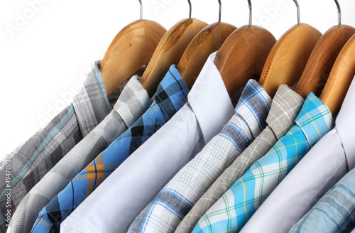 Photo: Shirts with ties on wooden hangers isolated on white Shirts with ties on wooden hangers isolated on white