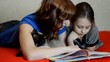 Mother and daughter reading a book with enthusiasm