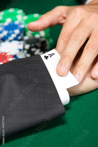 Photo: Poker player cheats with card from the sleeve Poker player cheats with card from the sleeve