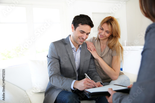 Photo: Couple signing terms of real-estate contract Couple signing terms of real-estate contract
