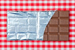 Tafel Schokolade auf kariertem Tischtuch