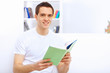 Young man at home with a book