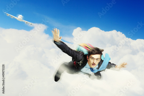Photo: Young businessman flying with parachute on back Young businessman flying with parachute on back