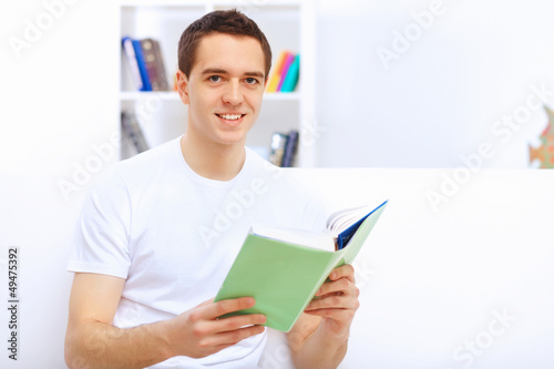 Photo: Young man at home with a book Young man at home with a book
