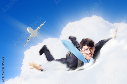 Photo: Young businessman flying with parachute on back Young businessman flying with parachute on back