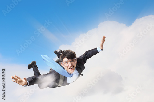 Photo: Young businessman flying with parachute on back Young businessman flying with parachute on back