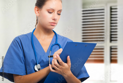 Photo: Nurse writing on a clipboard Nurse writing on a clipboard