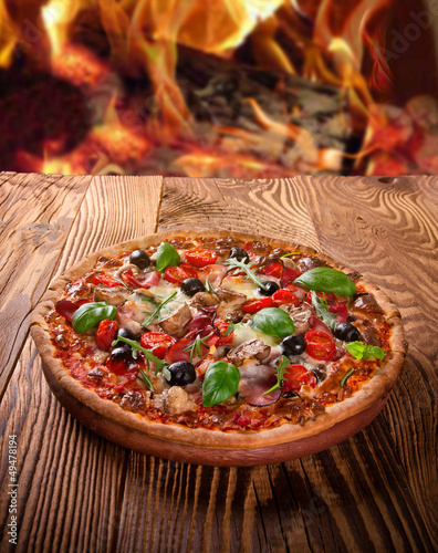 Photo: Delicious italian pizza served on wooden table Delicious italian pizza served on wooden table