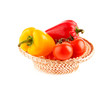 tomatoes and peppers in a wicker basket on a white background