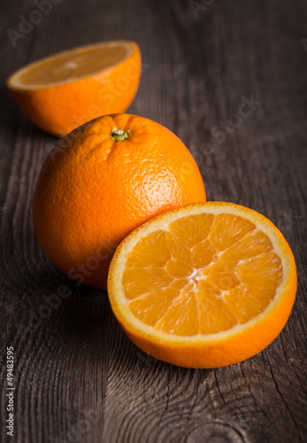 Photo: Close-up of orange fruit on on the old wooden table. Close-up of orange fruit on on the old wooden table.