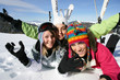 Photo: Three female friends laying in the snow Three female friends laying in the snow