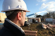 foreman in construction site with back turned to camera
