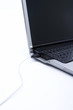 Laptop plugged with USB cable, close up