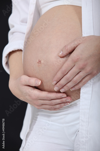 Photo: Woman stroking her pregnant belly Woman stroking her pregnant belly