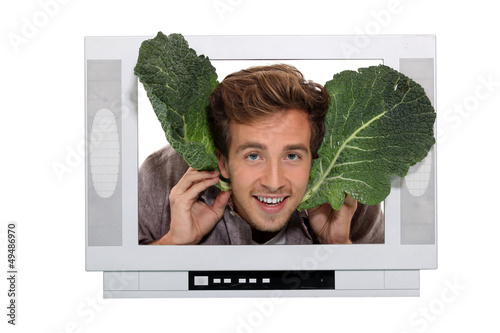 Photo: Man with cabbage leaves inside a television Man with cabbage leaves inside a television