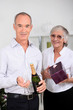 Older couple with champagne and a gift