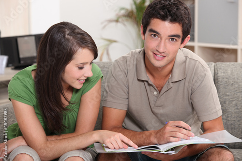 Photo: young couple at home skimming through catalogue young couple at home skimming through catalogue