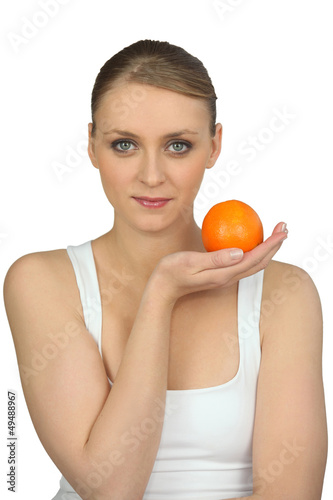 Photo: Young woman holding an orange Young woman holding an orange