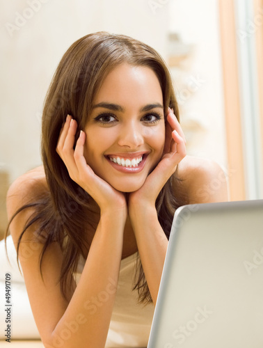 Photo: Cheerfull smiling woman working with laptop Cheerfull smiling woman working with laptop