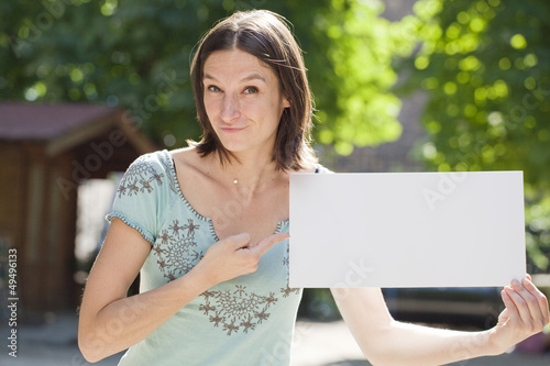 Photo: happy young woman showing something on a board happy young woman showing something on a board